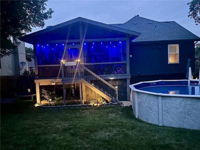 1641 N Hunter Dr, Olathe, KS 66061 - rear view of property featuring a shingled roof, a lawn, stairs, and an outdoor pool