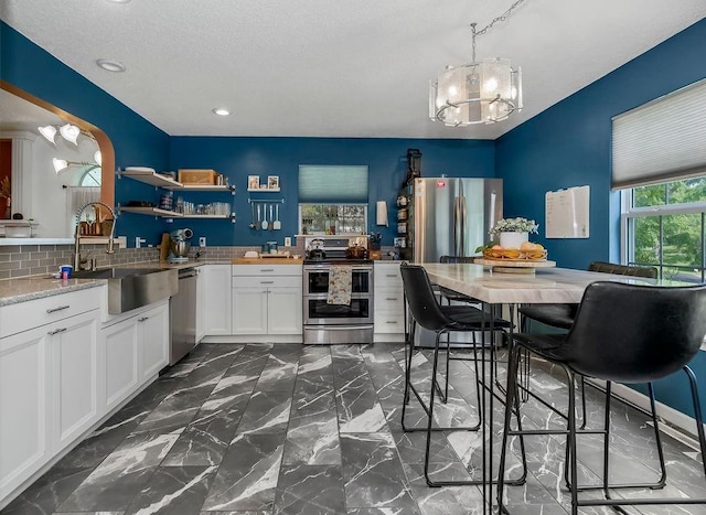 118 SE 215th Rd, Warrensburg, MO 64093 - kitchen featuring appliances with stainless steel finishes, a chandelier, white cabinets, open shelves, and recessed lighting