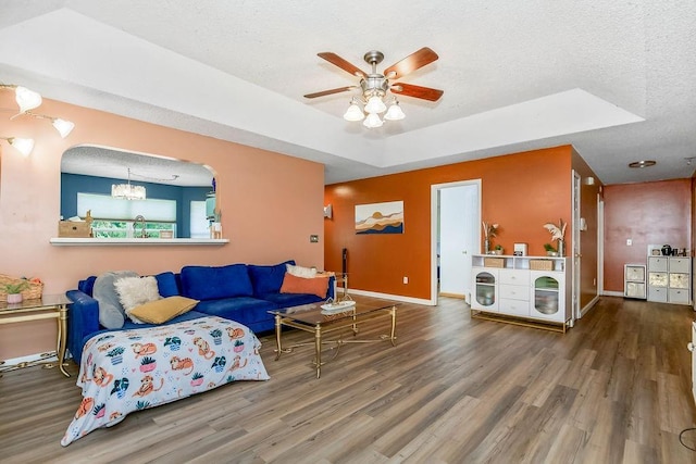 118 SE 215th Rd, Warrensburg, MO 64093 - living area featuring wood finished floors, a ceiling fan, a textured ceiling, a chandelier, and arched walkways