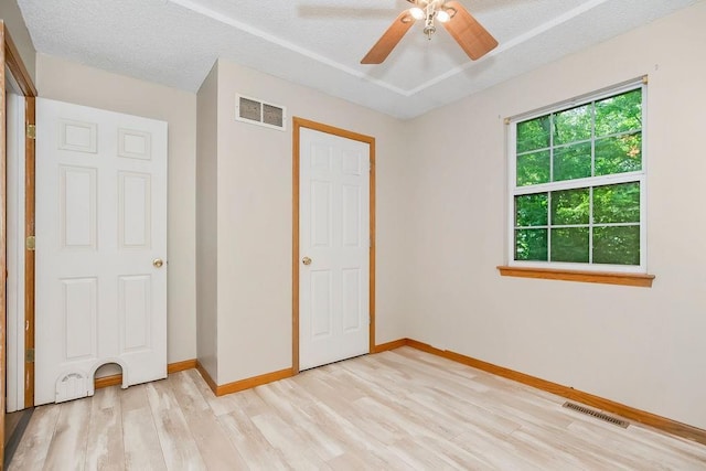 118 SE 215th Rd, Warrensburg, MO 64093 - unfurnished bedroom featuring light wood finished floors, a textured ceiling, and ceiling fan