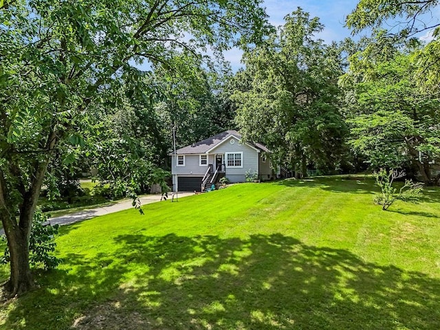 118 SE 215th Rd, Warrensburg, MO 64093 - view of green lawn featuring a garage and driveway