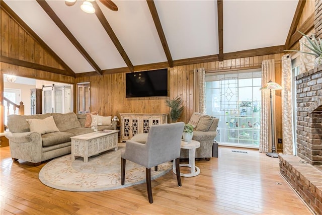 8404 Rosehill Rd, Lenexa, KS 66215 - living room featuring beamed ceiling, plenty of natural light, a brick fireplace, light wood finished floors, and a ceiling fan