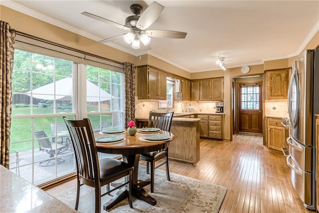 8404 Rosehill Rd, Lenexa, KS 66215 - dining area with light wood-style floors, a ceiling fan, and crown molding