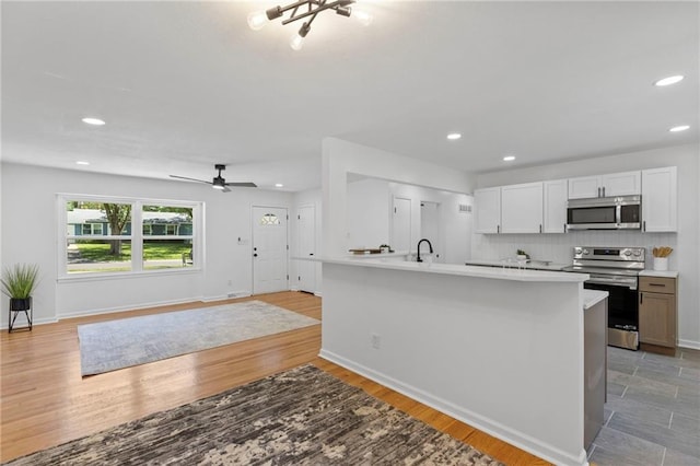 8918 Switzer St, Overland Park, KS 66214 - kitchen with appliances with stainless steel finishes, light countertops, recessed lighting, decorative backsplash, and open floor plan