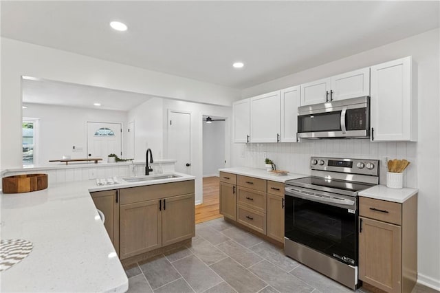 8918 Switzer St, Overland Park, KS 66214 - kitchen with appliances with stainless steel finishes, tasteful backsplash, recessed lighting, light stone countertops, and white cabinets