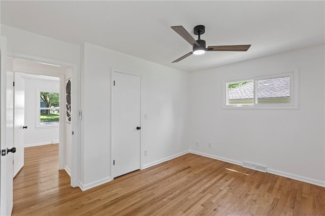 8918 Switzer St, Overland Park, KS 66214 - unfurnished bedroom with light wood-style flooring, multiple windows, and ceiling fan