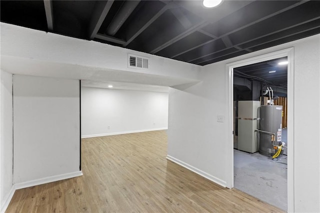 8918 Switzer St, Overland Park, KS 66214 - finished below grade area featuring gas water heater, fridge, and wood finished floors