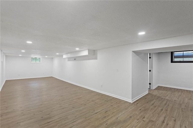 8918 Switzer St, Overland Park, KS 66214 - basement featuring wood finished floors, a textured ceiling, recessed lighting, and plenty of natural light