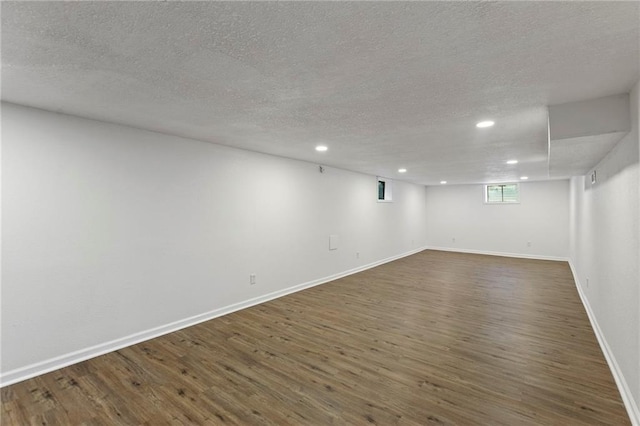 8918 Switzer St, Overland Park, KS 66214 - below grade area featuring dark wood-style floors, a textured ceiling, and recessed lighting