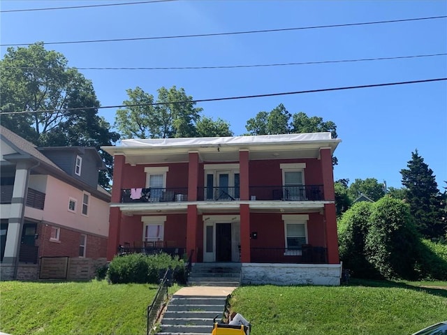3437 E 6th St, Kansas City, MO 64124 - view of front facade featuring a balcony, covered porch, and a front lawn