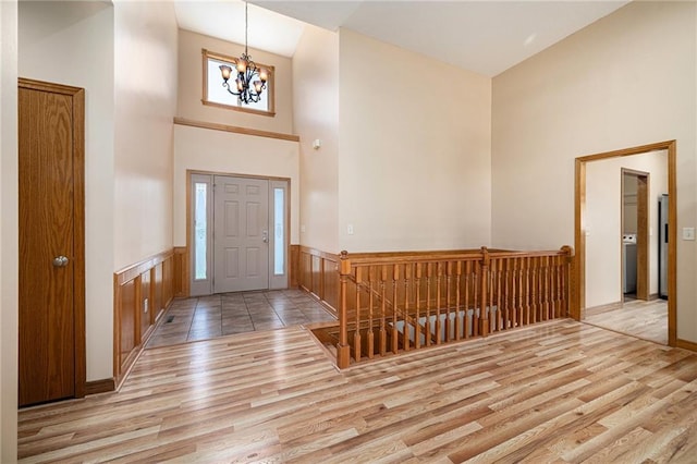 19208 E Lynchburg Pl, Independence, MO 64058 - foyer featuring a towering ceiling, wood finished floors, a chandelier, and wainscoting