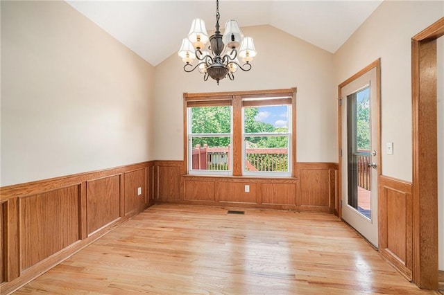 19208 E Lynchburg Pl, Independence, MO 64058 - empty room featuring light wood-style floors, a chandelier, wainscoting, vaulted ceiling, and healthy amount of natural light