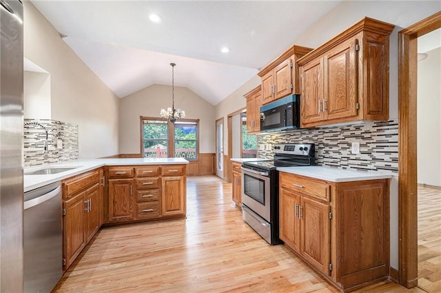 19208 E Lynchburg Pl, Independence, MO 64058 - kitchen featuring stainless steel appliances, light wood-type flooring, a peninsula, a chandelier, and vaulted ceiling