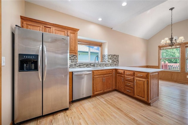 19208 E Lynchburg Pl, Independence, MO 64058 - kitchen featuring appliances with stainless steel finishes, light wood finished floors, a peninsula, light countertops, and lofted ceiling