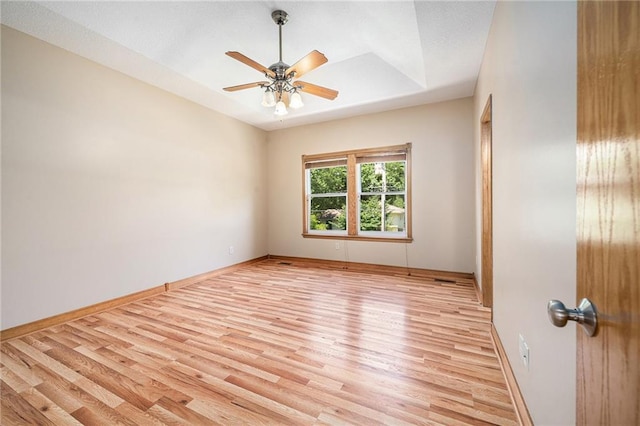 19208 E Lynchburg Pl, Independence, MO 64058 - empty room featuring light wood-type flooring, a ceiling fan, and a tray ceiling