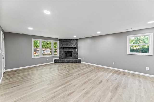 5513 Hardy Ave, Raytown, MO 64133 - unfurnished living room featuring recessed lighting, light wood finished floors, and a stone fireplace