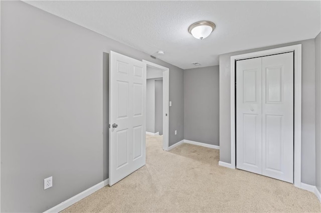 5513 Hardy Ave, Raytown, MO 64133 - unfurnished bedroom with light colored carpet, a closet, and a textured ceiling