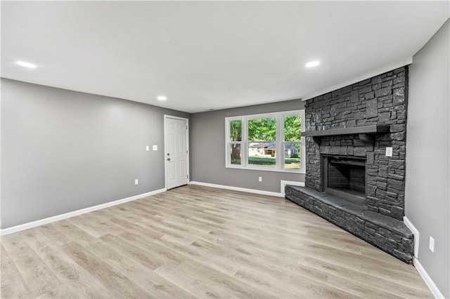 5513 Hardy Ave, Raytown, MO 64133 - unfurnished living room featuring a fireplace, wood finished floors, and recessed lighting