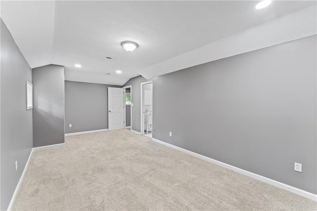 5513 Hardy Ave, Raytown, MO 64133 - carpeted empty room featuring lofted ceiling, a textured ceiling, and recessed lighting