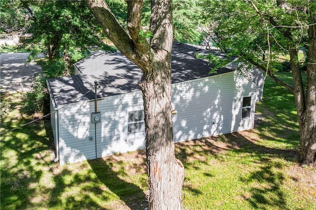 5513 Hardy Ave, Raytown, MO 64133 - view of side of home with a shingled roof and a lawn