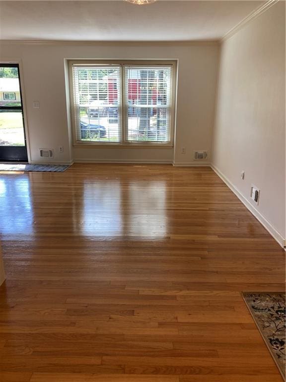 7909 Appleton Ave, Raytown, MO 64138 - empty room featuring crown molding, plenty of natural light, and wood finished floors