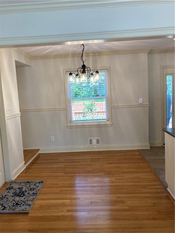7909 Appleton Ave, Raytown, MO 64138 - unfurnished dining area featuring wood finished floors and crown molding