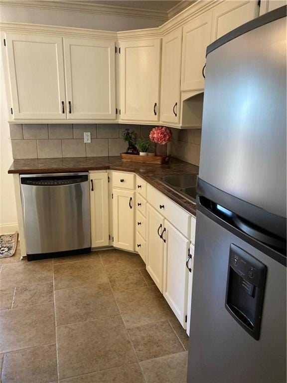 7909 Appleton Ave, Raytown, MO 64138 - kitchen featuring stainless steel appliances, dark countertops, tasteful backsplash, and ornamental molding