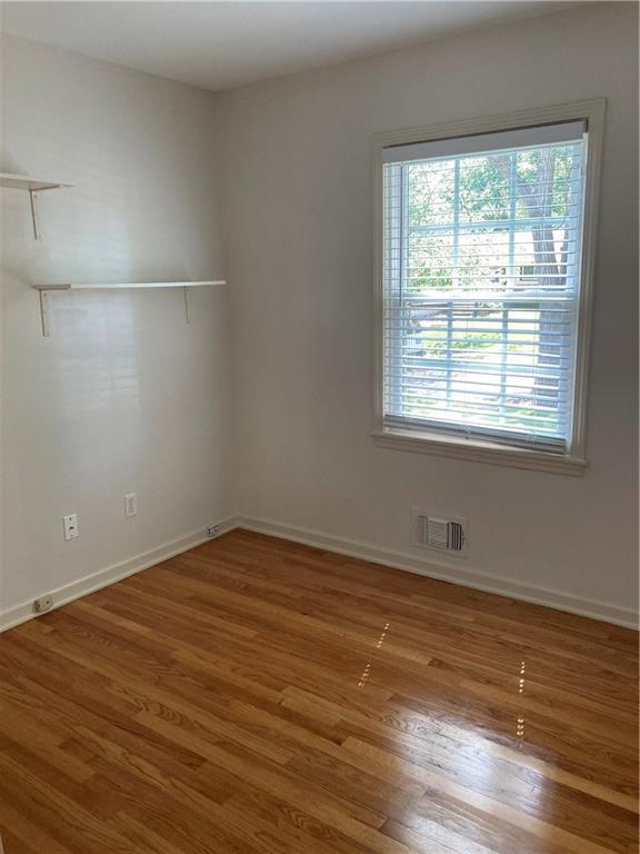 7909 Appleton Ave, Raytown, MO 64138 - empty room featuring plenty of natural light and wood finished floors