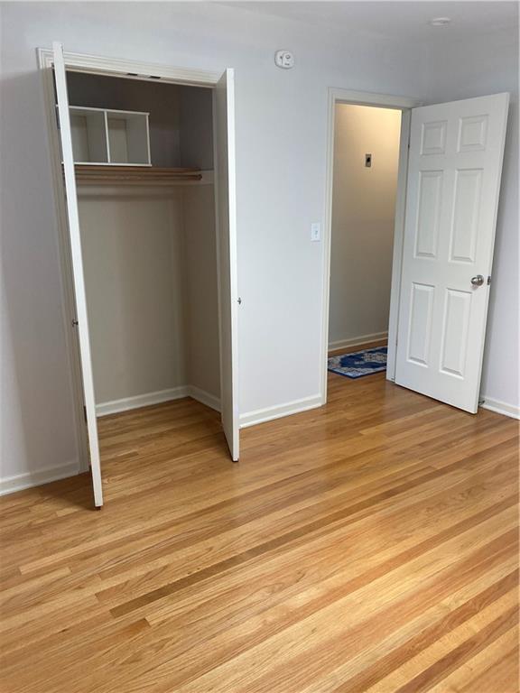 7909 Appleton Ave, Raytown, MO 64138 - unfurnished bedroom with a closet and light wood-style floors