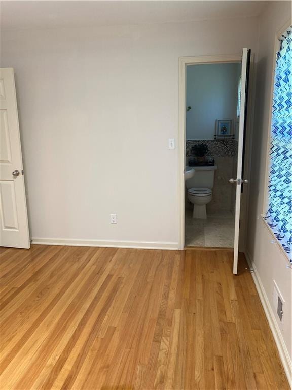 7909 Appleton Ave, Raytown, MO 64138 - unfurnished bedroom featuring light wood-style floors and ensuite bathroom