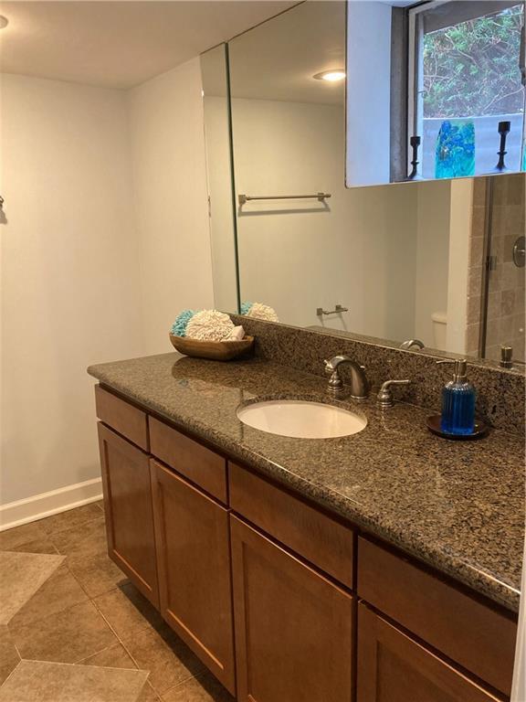 7909 Appleton Ave, Raytown, MO 64138 - bathroom featuring vanity, tile patterned flooring, and a shower