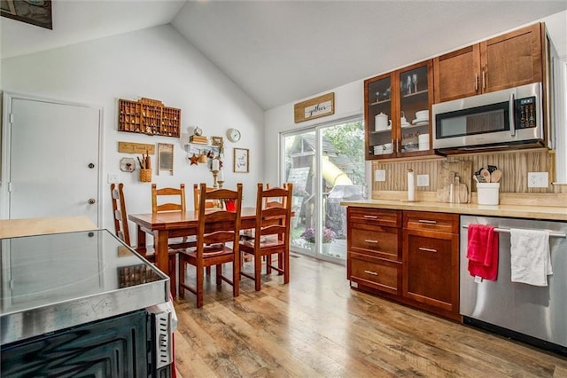 12508 Valley Brook Dr, Grandview, MO 64030 - kitchen featuring stainless steel appliances, light wood-type flooring, glass insert cabinets, high vaulted ceiling, and light countertops