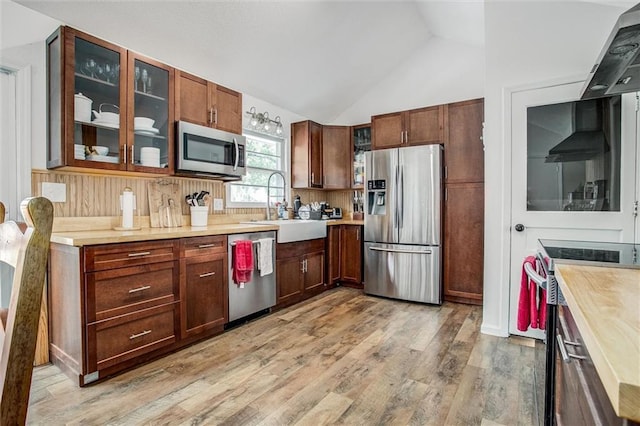 12508 Valley Brook Dr, Grandview, MO 64030 - kitchen featuring appliances with stainless steel finishes, wall chimney range hood, light wood-style floors, light countertops, and vaulted ceiling