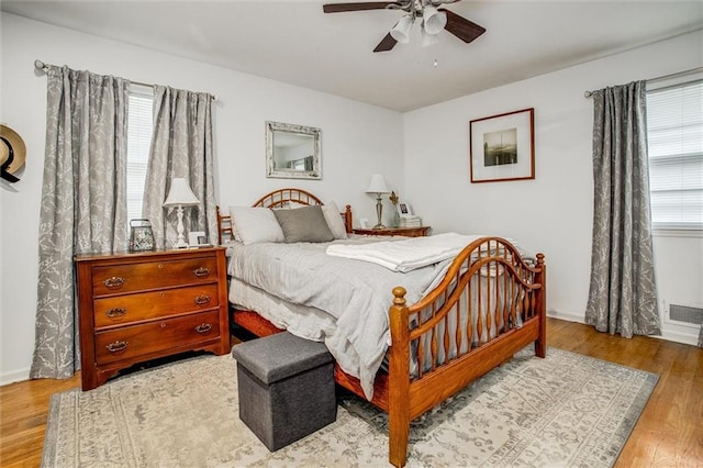 12508 Valley Brook Dr, Grandview, MO 64030 - bedroom with multiple windows, wood finished floors, and ceiling fan