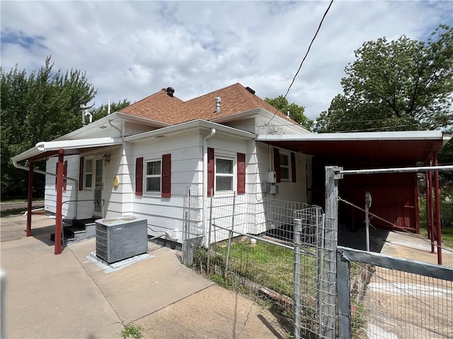 409 S Buckeye St, Iola, KS 66749 - view of property exterior featuring a cooling unit and roof with shingles