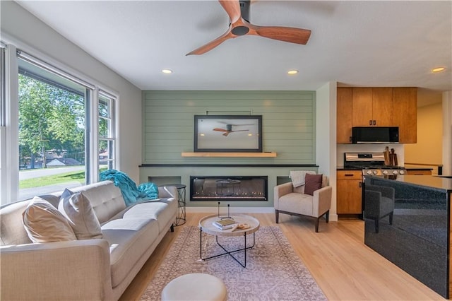2031 N 75th St, Kansas City, KS 66109 - living room with light wood-style flooring, a glass covered fireplace, recessed lighting, and a ceiling fan