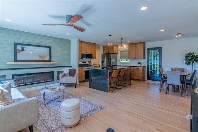 2031 N 75th St, Kansas City, KS 66109 - living area with ceiling fan, light wood-style floors, recessed lighting, and a glass covered fireplace