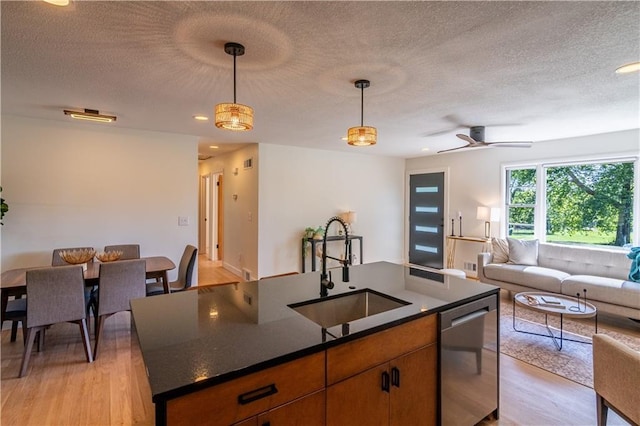 2031 N 75th St, Kansas City, KS 66109 - kitchen featuring dishwasher, open floor plan, light wood-type flooring, dark countertops, and a textured ceiling