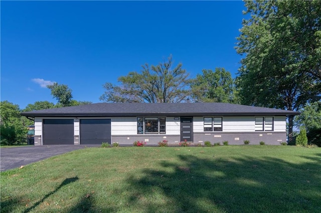 2031 N 75th St, Kansas City, KS 66109 - view of front of home with asphalt driveway, a garage, and a front yard