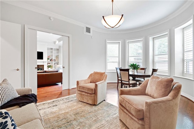 4900 Central St Unit 104, Kansas City, MO 64112 - living area featuring crown molding, plenty of natural light, light wood-style floors, and built in shelves