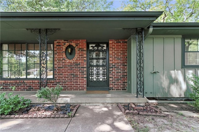 7100 Antioch Rd, Merriam, KS 66204 - doorway to property with brick siding, covered porch, and board and batten siding