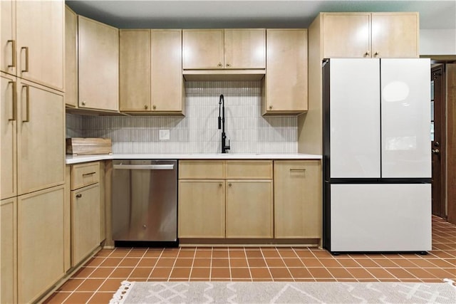 7100 Antioch Rd, Merriam, KS 66204 - kitchen with freestanding refrigerator, stainless steel dishwasher, light countertops, and light brown cabinetry