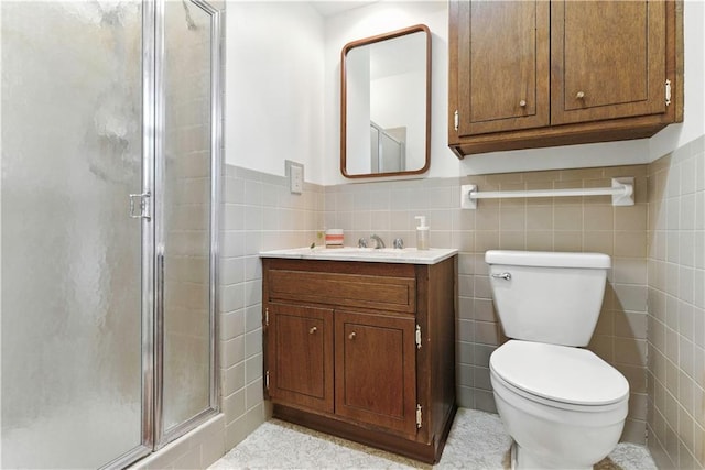 7100 Antioch Rd, Merriam, KS 66204 - bathroom featuring a shower stall, vanity, tile walls, and wainscoting