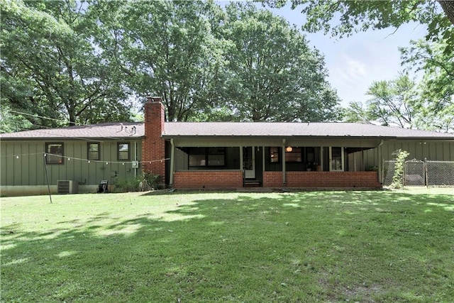 7100 Antioch Rd, Merriam, KS 66204 - rear view of house featuring board and batten siding, a chimney, and a sunroom