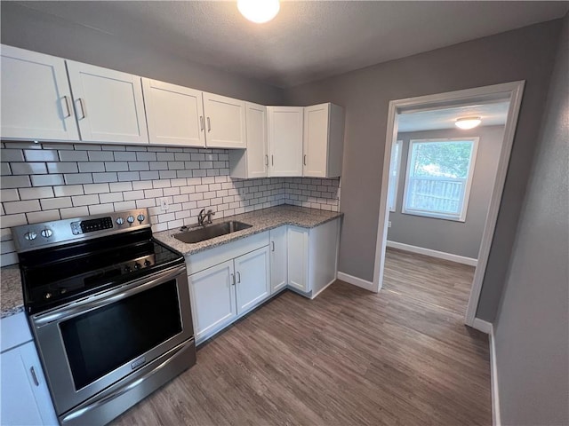 11117 E 15th St S, Independence, MO 64052 - kitchen featuring electric stove, wood finished floors, decorative backsplash, white cabinets, and light stone counters