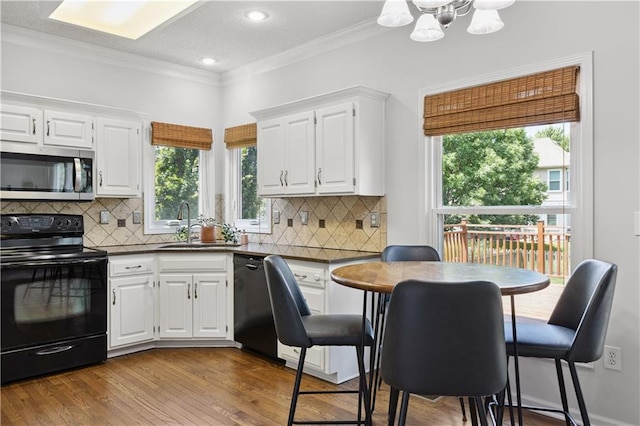 14162 W 150th Ct, Olathe, KS 66062 - kitchen with black appliances, dark countertops, crown molding, white cabinets, and a chandelier