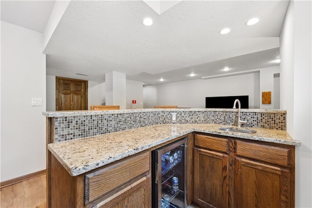 14162 W 150th Ct, Olathe, KS 66062 - kitchen with beverage cooler, tasteful backsplash, a textured ceiling, recessed lighting, and light stone counters