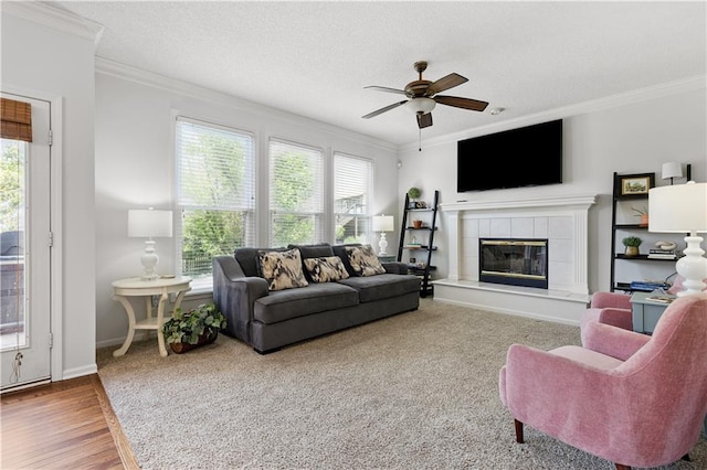 14162 W 150th Ct, Olathe, KS 66062 - living room featuring ornamental molding, ceiling fan, a tile fireplace, a textured ceiling, and wood finished floors
