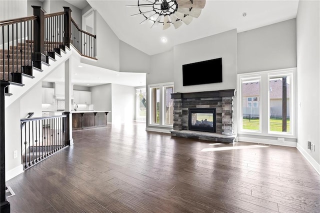 704 SW Admiral Byrd Dr, Lees Summit, MO 64082 - unfurnished living room featuring high vaulted ceiling, dark wood-type flooring, and a stone fireplace