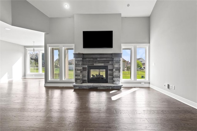 704 SW Admiral Byrd Dr, Lees Summit, MO 64082 - unfurnished living room featuring a stone fireplace, hardwood / wood-style floors, and a high ceiling